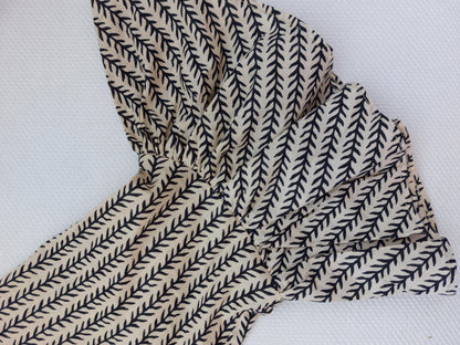Détail du tissu et des finitions : blouse en coton noir et beige à volants