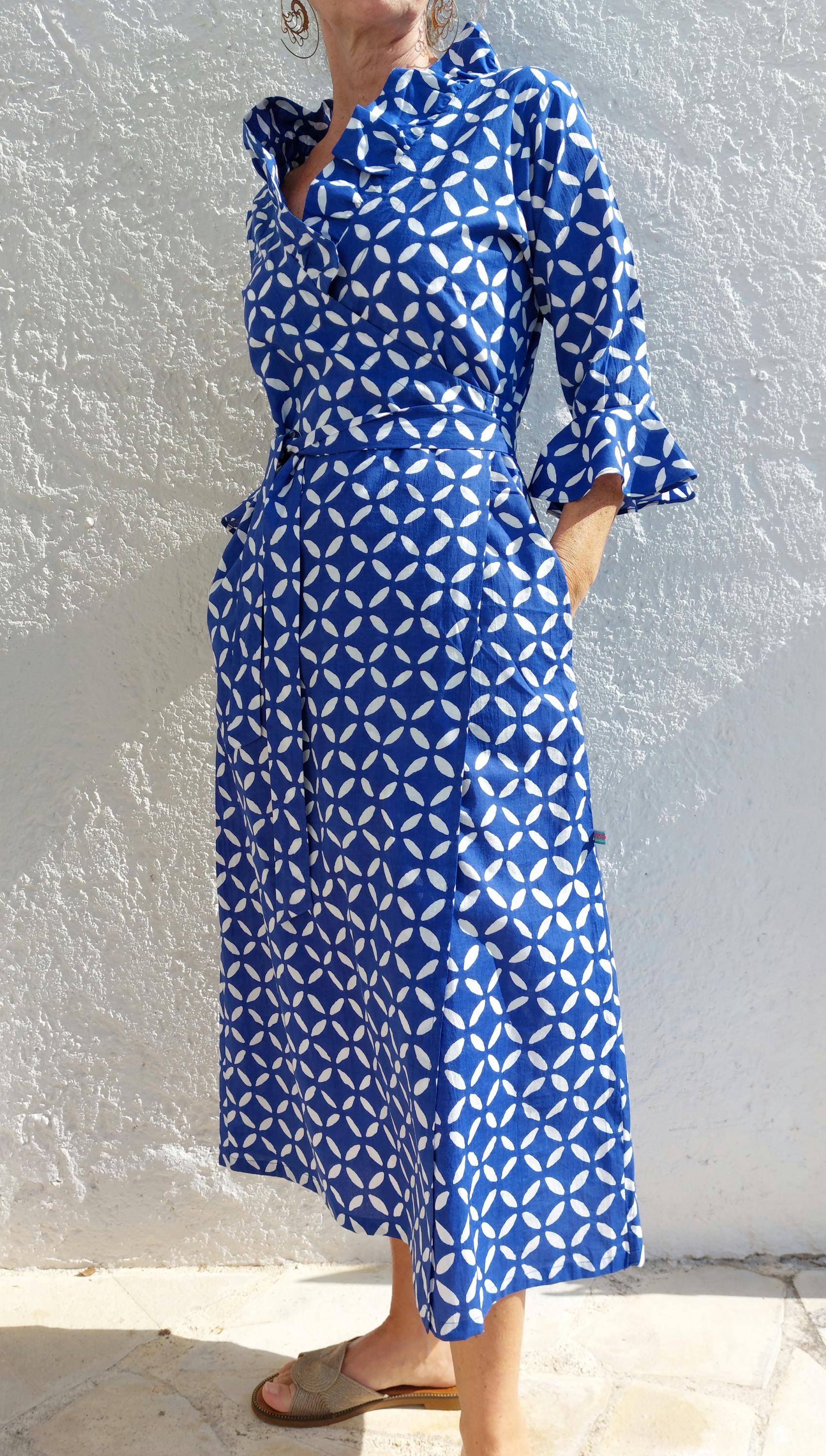 Peut inclure: Une robe portefeuille à motif bleu et blanc avec un col à volants et des manches 3/4. La robe a une ceinture à nouer et des poches.