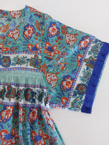 Détail du tissu et des finitions : robe ample turquoise et orange, sequins bleus